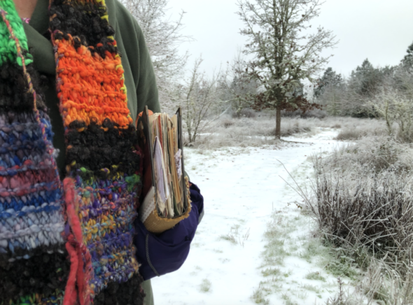 Holding journal on a snowy trail